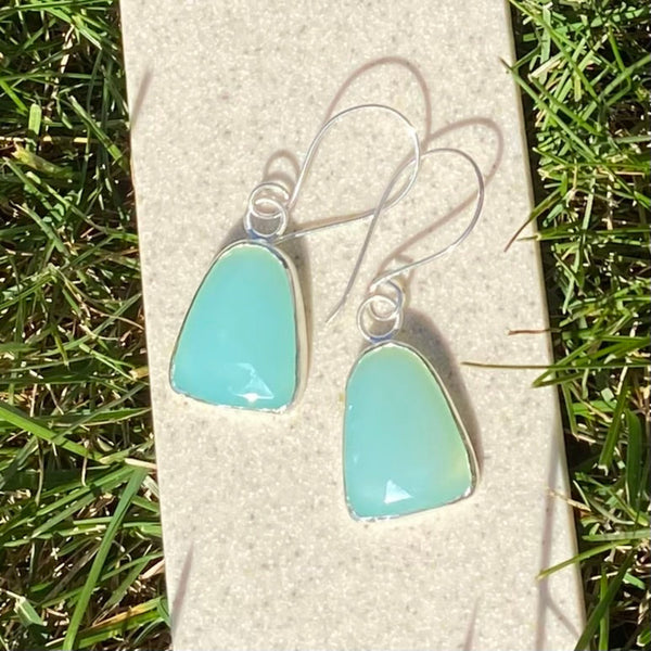 Wear these beautiful, brightly colored aqua earrings when you need the diplomacy Chalcedony can "bring to the tip of your tongue" (Tiny Rituals).  I'm thinking anytime but maybe family gatherings?  
Charm:  Rosecut Chalcedony set in Sterling Silver measures 1 1/4" long x 3/4" wide.
Ear Wires:  20gauge Argentium™ .  Total length of of earring with wires is 2 1/4" long.