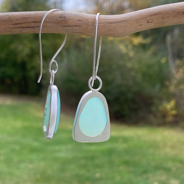 Wear these beautiful, brightly colored aqua earrings when you need the diplomacy Chalcedony can "bring to the tip of your tongue" (Tiny Rituals).  I'm thinking anytime but maybe family gatherings?  
Charm:  Rosecut Chalcedony set in Sterling Silver measures 1 1/4" long x 3/4" wide.
Ear Wires:  20gauge Argentium™ .  Total length of of earring with wires is 2 1/4" long.