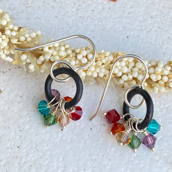 Did you know the Chakra colors are the same as the Pride colors which are the same as Rainbow colors?    Six Swarovski™ crystals (one for each color of the rainbow) dangle from repurposed black rubber washers and 20 gauge Argentium™ ear wires.  Washer 7/16" round  4mm Swarovski™   Charm Length: .75"  Charm Width:  .75" at widest part  Total length including ear wires:  1.25"