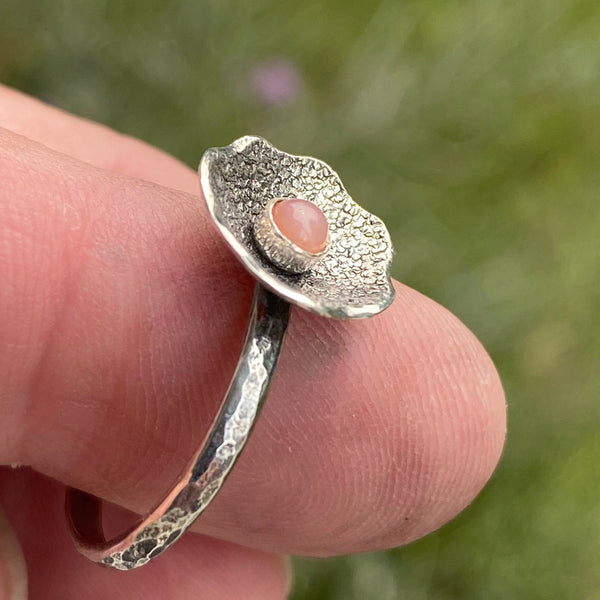 Textured and patinated Sterling Silver and a 3mm Peach Moonstone combine to create a delicate flower ring.  Peach Moonstone...such a powerful stone with much to offer.  A stone for wishing and hoping, it recognizes the difference between need and want on a universal level.  Size 7.75
