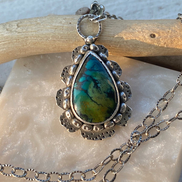 Blue and green are the predominant colors of this beautiful teardrop shaped Hubei Turquoise stone.  Measuring 17 x 11mm it is set in texturized layers of Sterling Sterling Silver.  Charm:  1.25L x .75W  Chain: 20" oxidized, patterned 2.8mm cable chain and handmade hook clasp.