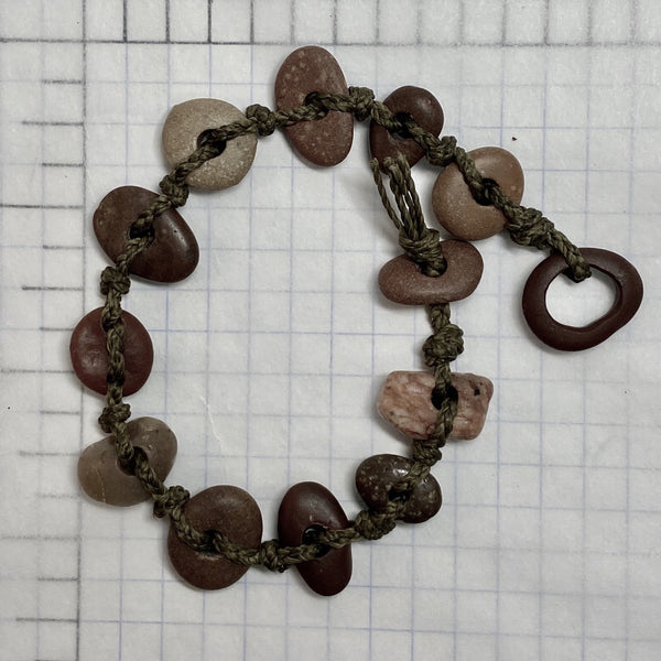 A day at the beach...The smell of suntan lotion.  The warmth of the sun on our skin.  The sounds of waves crashing and children laughing.  Bliss.  Made with hand drilled Lake Michigan beach stones in red-brown colors and khaki colored braided waxed linen cord, wear these bracelets to remind you of all things summer.  The toggle clasp is created from beach stones.  Total length- 8 1/2"  Fits up to 7 3/4" wrist