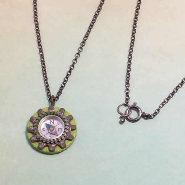 It works!  I know because I had to use my compass necklace one day when I got lost on my bike and didn't have my phone to guide me home!  The compass on this handmade necklace is surrounded by a zipper and a locking tooth washer and sewn to a painted wood and paper support.