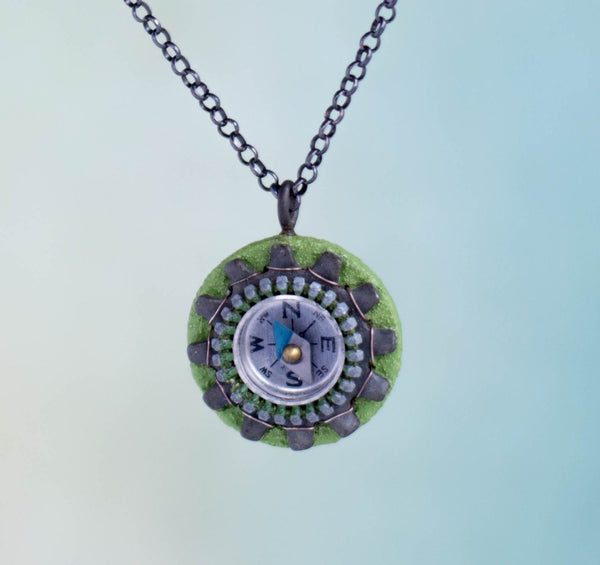 It works!  I know because I had to use my compass necklace one day when I got lost on my bike and didn't have my phone to guide me home!  The compass on this handmade necklace is surrounded by a zipper and a locking tooth washer and sewn to a painted wood and paper support.