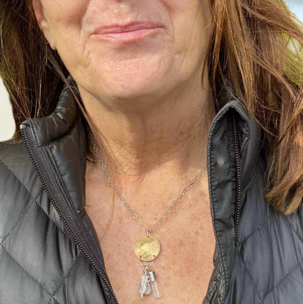 Need to start an Evolution Revolution?   Let Marianne, Spirit of the Revolution, ride with you! The vintage French brass coin features the words liberte, egalite and fraternite...liberty, equality, fraternity. She also carries a few charms...a Sterling Silver feather for flight/freedom, Quartz Crystal (known as a master healer) and a bit of beach glass set in Sterling Silver with a heart cut into it.
Charm: 2" long x 3/4" wide
Chain: 18" textured and patinated 2.8mm Sterling