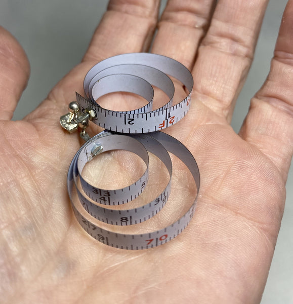 A wonderful flea market find inspired me to make these earrings based on a 1990's Nike ad (see blog).  Somewhat of a limited edition because that's what happens with found objects.  When they're gone, they are gone.  Made from vintage tape measures, micro-screws hold the three concentric loops of each earring together.  Charm:  1.5" length, 1.25" width (approx. 1 1/8" diameter)  Total length:  1.5"  Sterling Silver posts