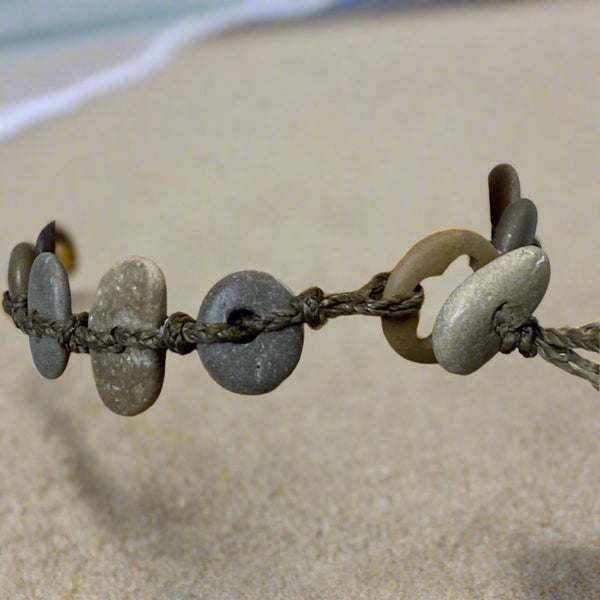 A day at the beach...The smell of suntan lotion.  The warmth of the sun on our skin.  The sounds of waves crashing and children laughing.  Bliss.  Made with hand drilled Lake Michigan beach stones in green-brown colors and khaki colored braided waxed cotton cord.  The toggle clasp is created from beach stones.  Total length- 8 1/2"  Fits up to 7 3/4" wrist