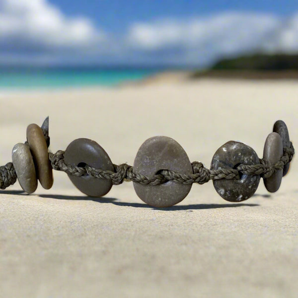 A day at the beach...The smell of suntan lotion.  The warmth of the sun on our skin.  The sounds of waves crashing and children laughing.  Bliss.  Made with hand drilled Lake Michigan beach stones in green-brown colors and khaki colored braided waxed cotton cord.  The toggle clasp is created from beach stones.  Total length- 8 1/2"  Fits up to 7 3/4" wrist
