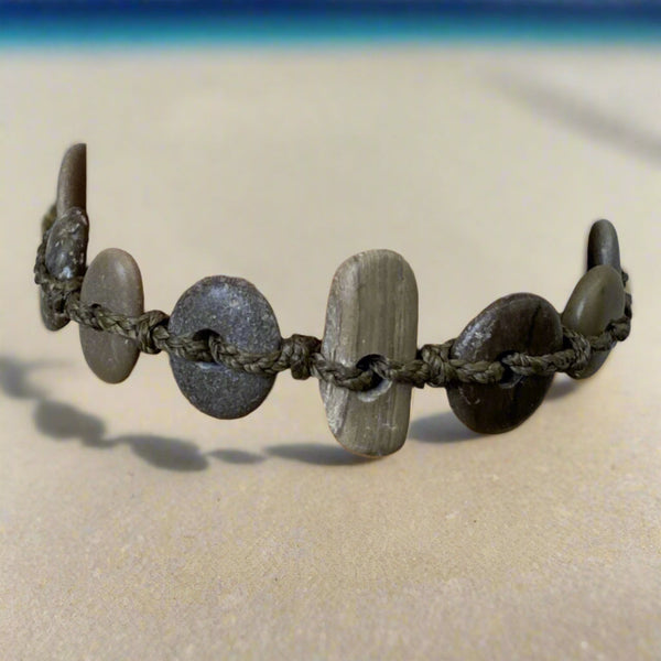 A day at the beach...The smell of suntan lotion.  The warmth of the sun on our skin.  The sounds of waves crashing and children laughing.  Bliss.  Made with hand drilled Lake Michigan beach stones in green-brown colors and khaki colored braided waxed cotton cord.  The toggle clasp is created from beach stones.  Total length- 8 1/2"  Fits up to 7 3/4" wrist