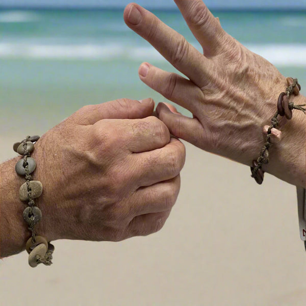 A day at the beach...The smell of suntan lotion.  The warmth of the sun on our skin.  The sounds of waves crashing and children laughing.  Bliss.  Made with hand drilled Lake Michigan beach stones in green-brown colors and khaki colored braided waxed cotton cord.  The toggle clasp is created from beach stones.  Total length- 8 1/2"  Fits up to 7 3/4" wrist