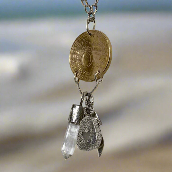 Need to start an Evolution Revolution? Let Marianne, Spirit of the Revolution, ride with you! The vintage French brass coin features the words liberte, egalite and fraternite...liberty, equality, fraternity. She also carries a few charms...a Sterling Silver feather for flight/freedom, Quartz Crystal (known as a master healer) and a bit of beach glass set in Sterling Silver with a heart cut into it.
Charm: 2" long x 3/4" wide
Chain: 18" textured and patinated 2.8mm Sterling Silver