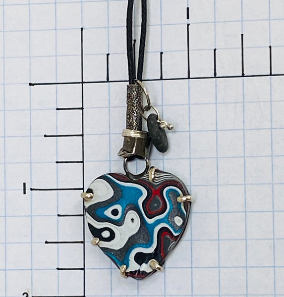 Yup.  I am a total muscle car geek which is why I LOVE this material.  Fordite is created from layers of vintage, enamel car paint that built up during the paint process in factories.  Check out my blog for more detailed info.  1mm linen cord adjusts up to 28".  Fordite charm measures 1.5" long x 1" wide and is set in Sterling Silver.  It is embellished with a beach stone, "love" stamped on a small tube and various free form Sterling Silver circles.