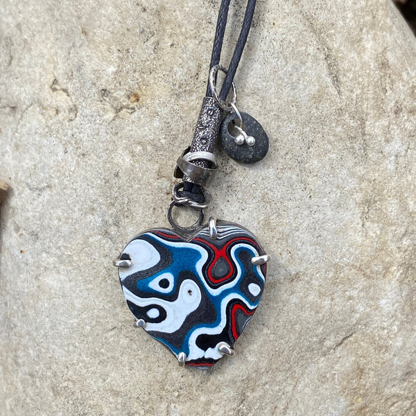 Yup.  I am a total muscle car geek which is why I LOVE this material.  Fordite is created from layers of vintage, enamel car paint that built up during the paint process in factories.  Check out my blog for more detailed info.  1mm linen cord adjusts up to 28".  Fordite charm measures 1.5" long x 1" wide and is set in Sterling Silver.  It is embellished with a beach stone, "love" stamped on a small tube and various free form Sterling Silver circles.