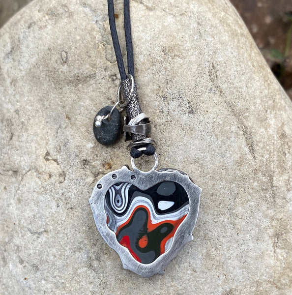 Yup.  I am a total muscle car geek which is why I LOVE this material.  Fordite is created from layers of vintage, enamel car paint that built up during the paint process in factories.  Check out my blog for more detailed info.  1mm linen cord adjusts up to 28".  Fordite charm measures 1.5" long x 1" wide and is set in Sterling Silver.  It is embellished with a beach stone, "love" stamped on a small tube and various free form Sterling Silver circles.