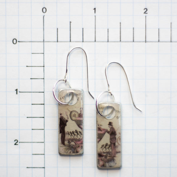 I do believe there’s a man in my martini!  That certainly makes it a gin kind of day! These handmade earrings are created from a Hendrix gin label and found object metal these earrings are filled with whimsy and fun.  They are sealed with resin.