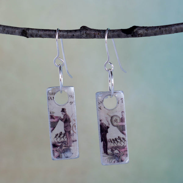 I do believe there’s a man in my martini!  That certainly makes it a gin kind of day! These handmade earrings are created from a Hendrix gin label and found object metal these earrings are filled with whimsy and fun.  They are sealed with resin.