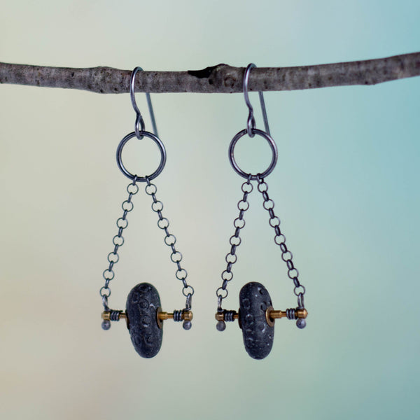 These handmade earrings feature little brass found objects gifted to me from a former stranger (Thank you, Mike) are a perfect support for the carved and brass riveted Lake Michigan beach stones.  Sterling Silver rolo chain finishes these kinetic earrings that rock and twist, moving with you.