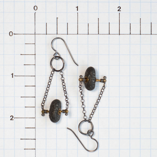 Let the gentle sounds these earrings make remind you of the kindness of strangers.  These handmade earrings feature little brass found objects gifted to me from a former stranger.  They are a perfect support for the carved and brass riveted Lake Michigan beach stones.  Sterling Silver rolo chain finishes these kinetic earrings that rock and twist, moving with you.