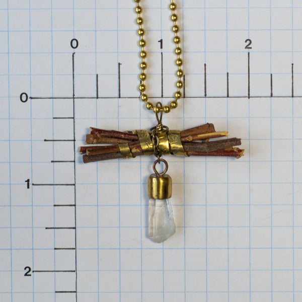 “Wisdom begins in wonder” (Socrates) is stamped on a brass band that wraps around a bundle of sticks on this handmade necklace.  Flashing light as it moves, a Quartz crystal dangles on a small, brass chain.