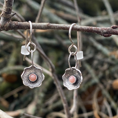 Pretty powerful stones, these 3mm peach moonstones. &nbsp; If you listen closely you might hear them whispering of intuition vs. reason. &nbsp;Or perhaps they will share their beliefs about need vs. want. &nbsp;

The pretty flowers are textured and domed Sterling Silver. &nbsp;They dangle from a Sterling Silver ear wire. &nbsp;

Charm size: &nbsp;3/8"

Length: &nbsp;1 3/8" in total length including ear wire.