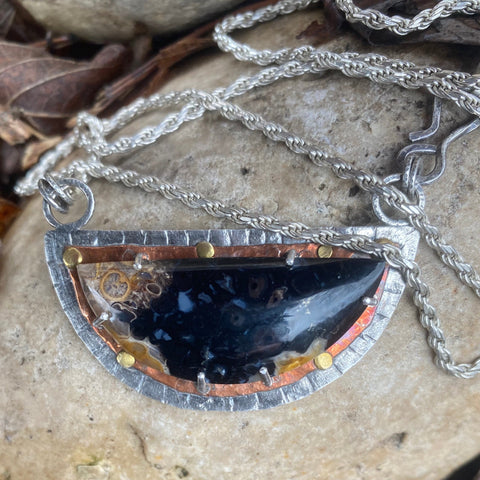 The beauty of Palmroot Agate...a petrified stone created with slowly evolving organic matter and tree roots.  Known for its potent earth medicine, it is said to offer you the ability to open a path for your own self evolution.  I could stare at this stone forever with it's intricate patterns and layers of color.  Charm:  Made with Sterling Silver, Copper and Brass, it measures 2.5" tall x 1.25" wide.  Chain:  20" long 2mm Sterling Silver French Rope chain.