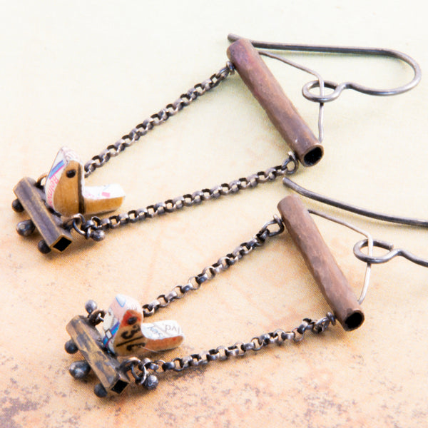 Who doesn't love hanging with a friend, sitting side by side as conversations meander from shoes to the meaning of life?  The handmade earrings feature tiny birds made using vintage rulers are edged in maps and have 1mm Black Spinel eyes.  The swing set is made with copper, brass, Sterling Silver and Argentium®.