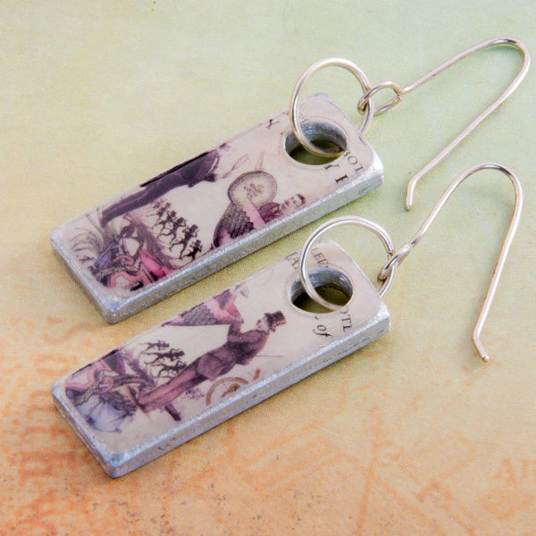 I do believe there’s a man in my martini!  That certainly makes it a gin kind of day! These handmade earrings are created from a Hendrix gin label and found object metal these earrings are filled with whimsy and fun.  They are sealed with resin.