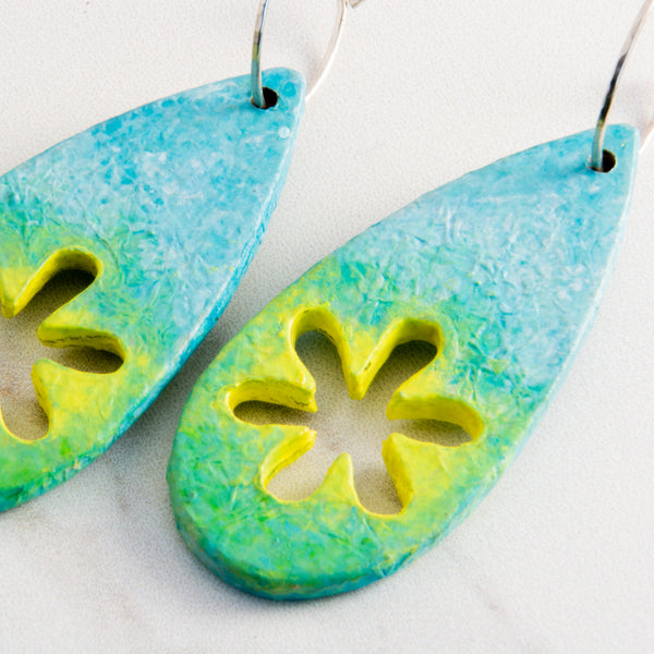 The rain has passed leaving blue skies, the smell of fresh grass and the yellow flowers have burst into bloom. The teardrop shaped earrings have been created from wood, paper and paint.
