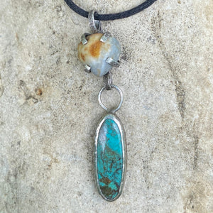 I love the feeling of wholeness that Turquoise offers...and the peace that a day at the beach brings.  An oblong Hubei Turquoise in a textured bezel and a prong set beach stone treasure hang from an adjustable cotton cord embellished with Sterling Silver beads.  Made with Sterling and Argentium™ Silver, the charm is 1 3/8"L x 1/2"W.  The cord adjusts from 16" to 24".